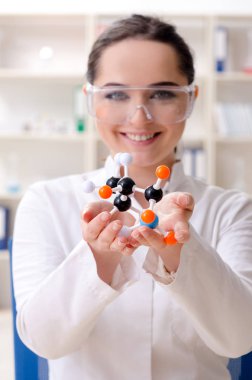 Laboratuvarda çalışan genç bir kadın kimyager. 