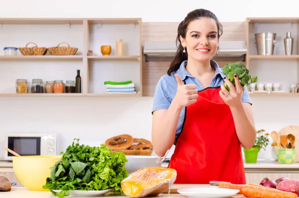 Mujer joven con verduras en la cocina — Foto de Stock