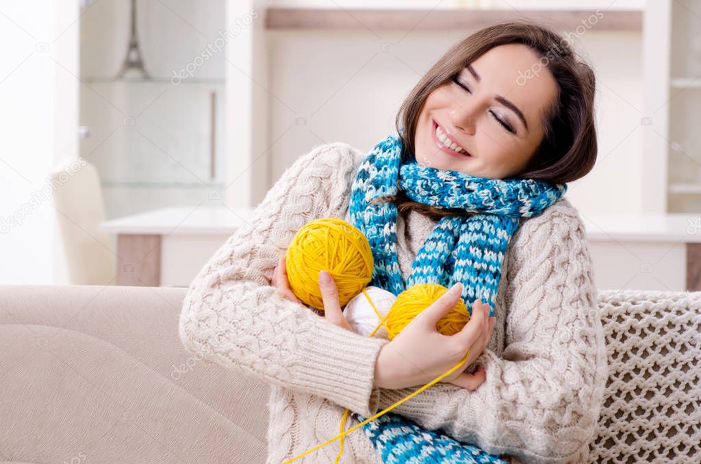 Young beautiful woman knitting at home 