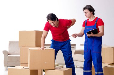 İki genç müteahhit kişisel eşyalarını taşıyor.