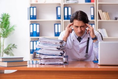 Klinikte çalışan yakışıklı genç bir doktor. 