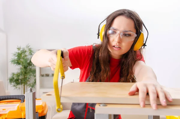 Female contractor repairing furniture at home