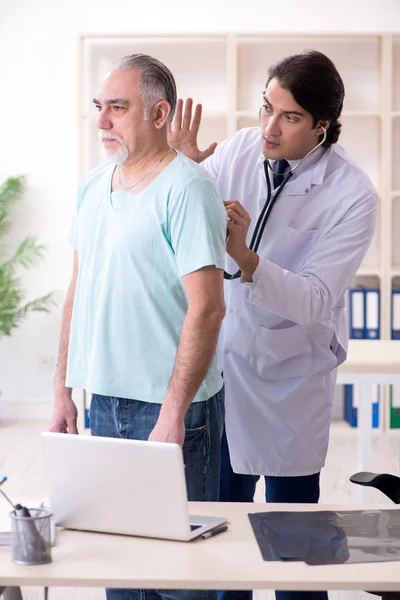 Yaşlı adam genç erkek doktoru ziyaret ediyor. — Stok fotoğraf