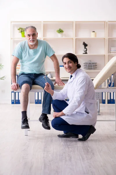 Viejo visitando joven doctor masculino — Foto de Stock