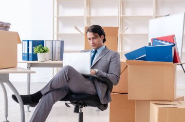 Genç adam çalışan ofiste kutuları ile 