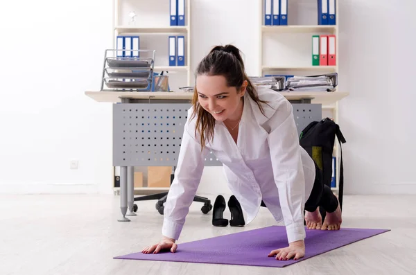 Жінка-працівник робить спортивні вправи в офісі — стокове фото
