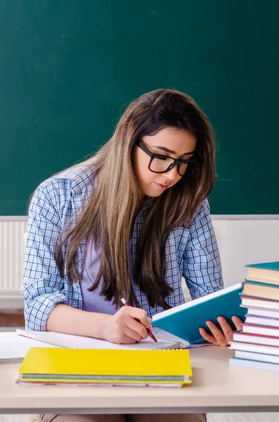 Estudante feminina na frente do quadro — Fotografia de Stock