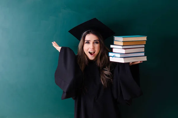 Female graduate student in front of green board — Stock Photo, Image