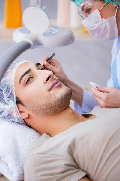 Jovem homem bonito visitando médico cosmetologista feminino — Fotografia de Stock