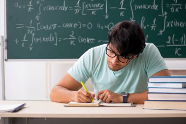 Kara tahta önünde genç erkek öğrenci matematikçi 