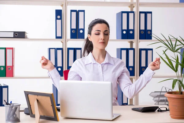 Junge Mitarbeiterin macht Übungen im Büro — Stockfoto