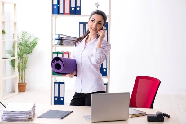 Jovem funcionária fazendo exercícios no escritório — Fotografia de Stock