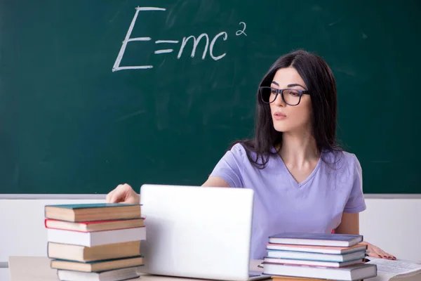 Jonge vrouwelijke leraar student in de voorkant van green board — Stockfoto
