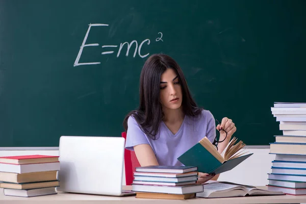 Jovem estudante professora na frente do quadro verde — Fotografia de Stock