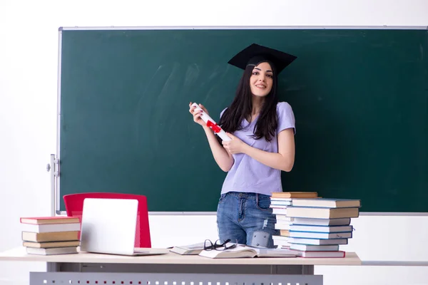 Étudiante diplômée devant le tableau vert — Photo