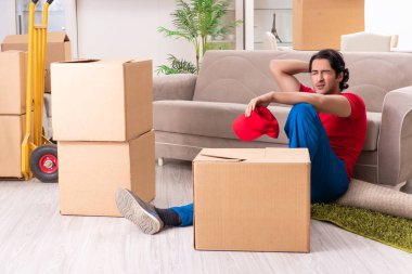 İçeride çalışan kutularla çalışan genç bir erkek müteahhit. 