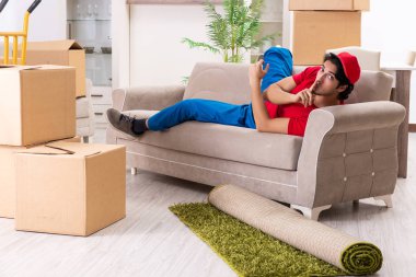 İçeride çalışan kutularla çalışan genç bir erkek müteahhit. 