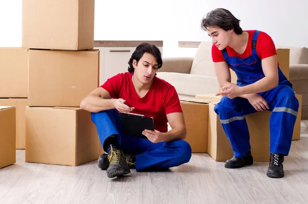 Dos empleados jóvenes del contratista moviendo pertenencias personales — Foto de Stock