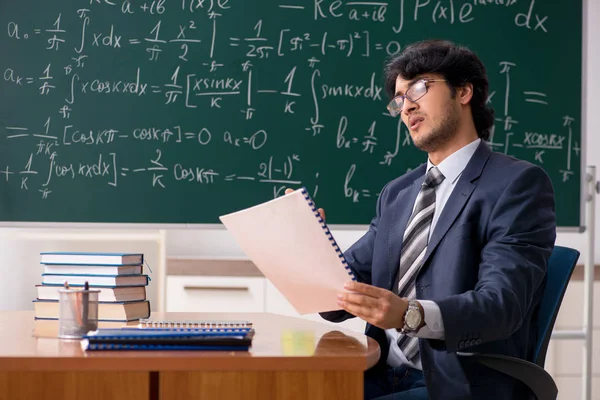 Young male math teacher in classroom