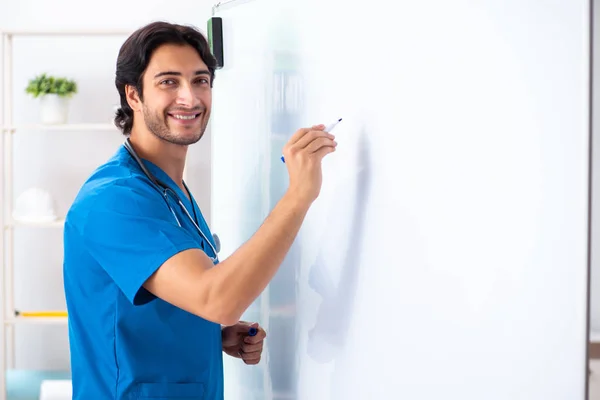 Ung manlig läkare framför whiteboard — Stockfoto