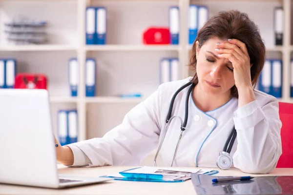 Aged female doctor working in the clinic — Stock Photo, Image