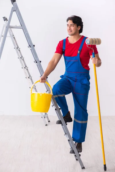 Jovem empreiteiro bonito trabalhando dentro de casa — Fotografia de Stock