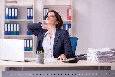 Ofiste acı çeken orta yaşlı kadın çalışan 