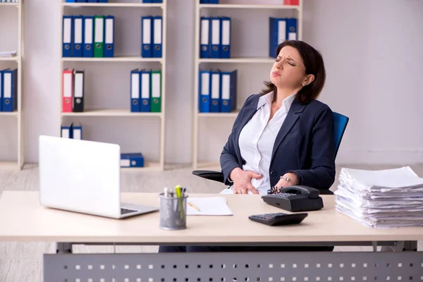 オフィスで苦しむ中年女性社員 — ストック写真