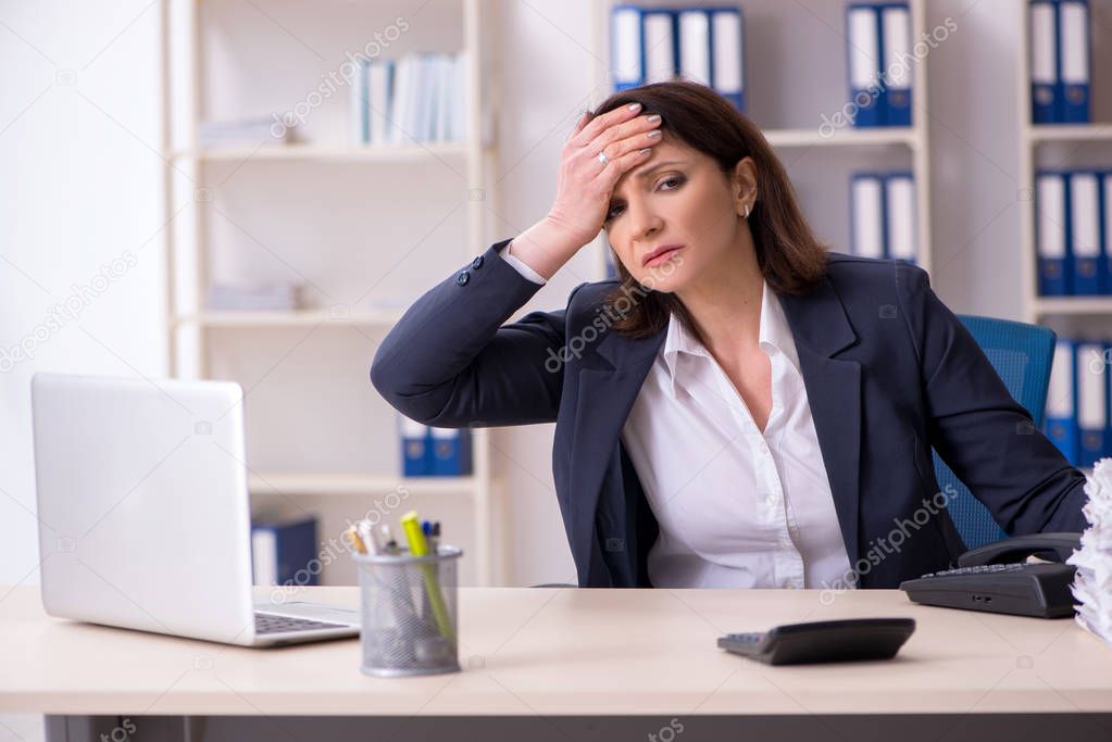 Middle-aged female employee suffering in the office 