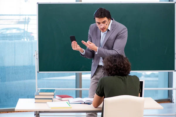 Jovem professor e aluno em sala de aula — Fotografia de Stock