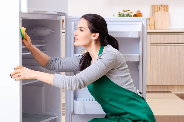 Young woman cleaning fridge in hygiene concept — Stock Photo, Image