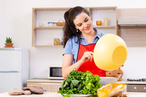 Jovem com legumes na cozinha — Fotografia de Stock