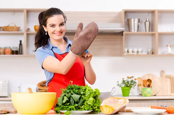 Jovem com legumes na cozinha — Fotografia de Stock