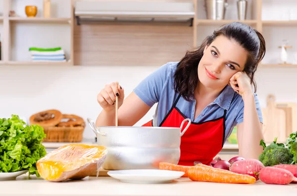 Jonge vrouw met groenten in de keuken — Stockfoto