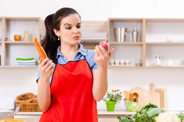 Молодая женщина с овощами на кухне — стоковое фото