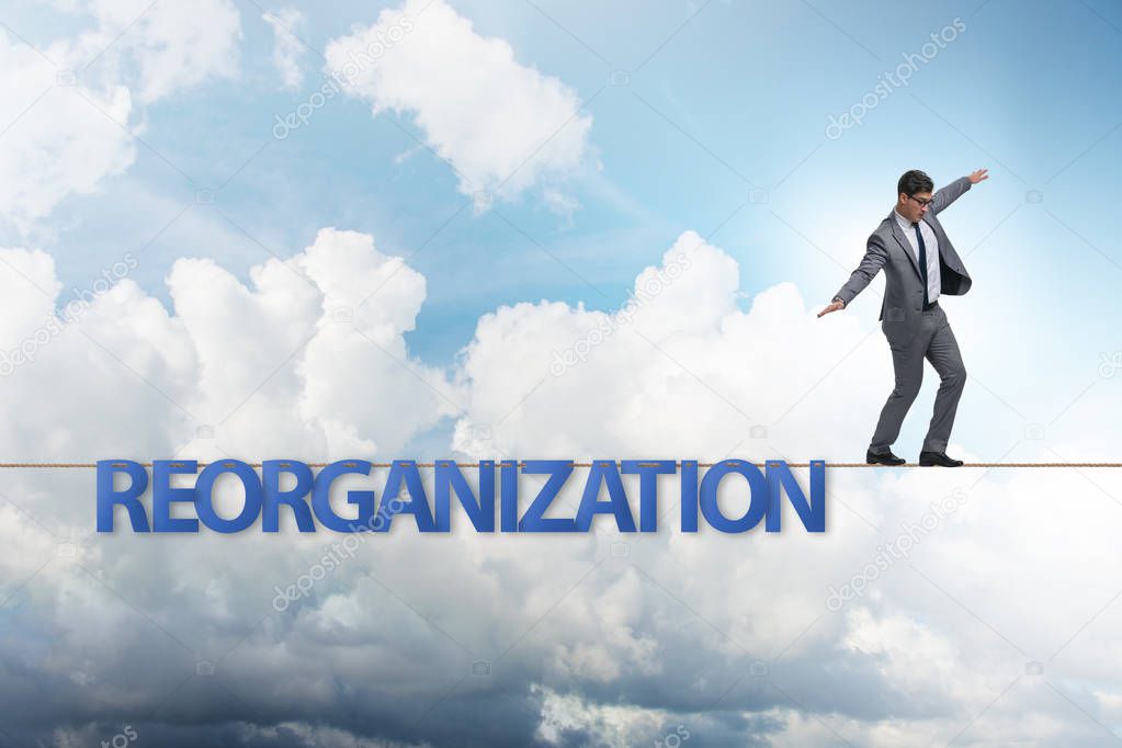 Reorganisation concept with businessman walking on tight rope