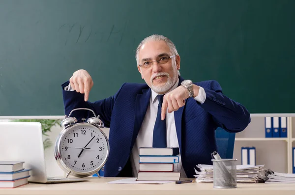 Leeftijd mannelijke leraar in de voorkant van schoolbord — Stockfoto