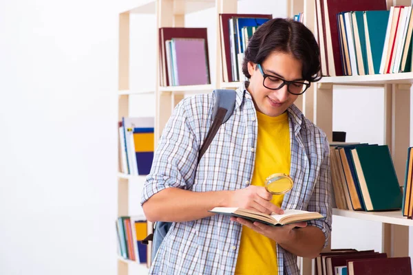 Estudante do sexo masculino se preparando para exames na biblioteca — Fotografia de Stock