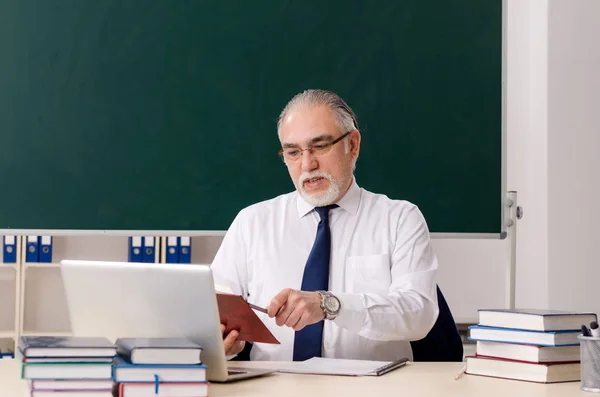 Leeftijd mannelijke leraar in de voorkant van schoolbord — Stockfoto