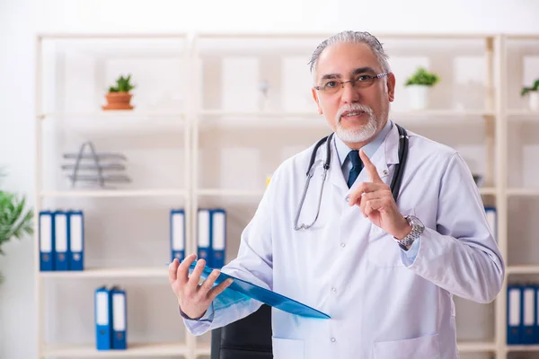 Médico idoso trabalhando na clínica — Fotografia de Stock