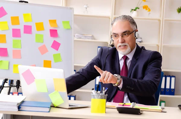 Dipendente uomo anziano in concetto di priorità contrastanti — Foto Stock