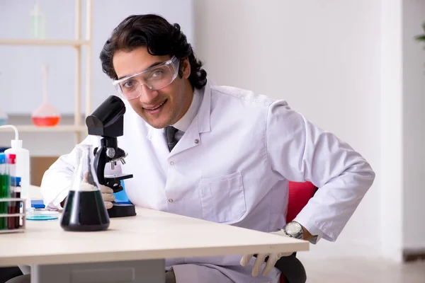 Mladý pohledný chemik pracující v laboratoři — Stock fotografie