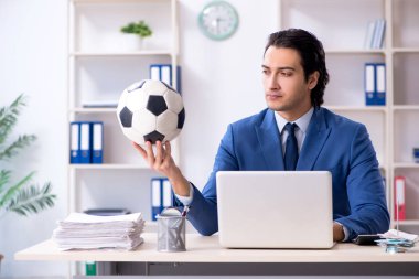 Genç yakışıklı işadamı ile ofiste futbol topu 