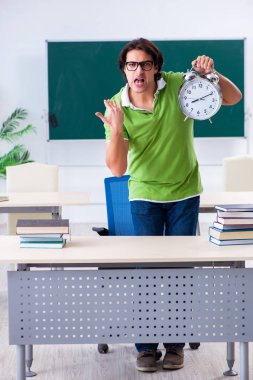 Yeşil panonun önünde genç bir erkek öğrenci. 