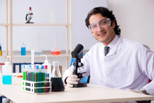 Jonge knappe chemicus die in het lab werkt — Stockfoto