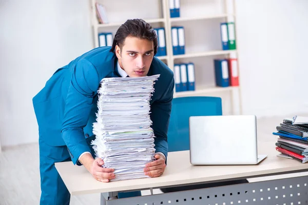 Joven empleado masculino infeliz con el trabajo excesivo — Foto de Stock