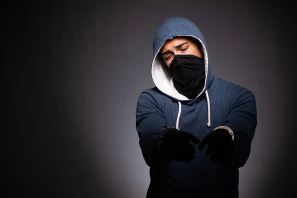 Young gangster in hood on grey background — Stock Photo, Image