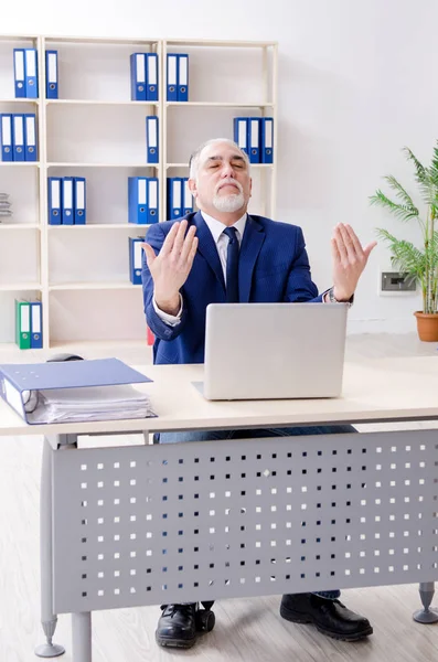 Homme d'affaires âgé faisant des exercices de yoga dans le bureau — Photo