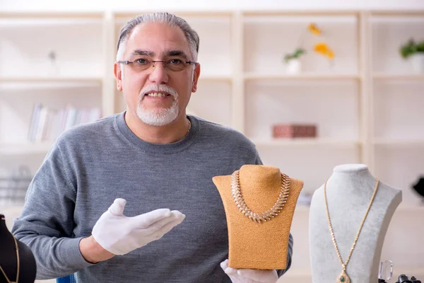 White bearded old jeweler at workshop