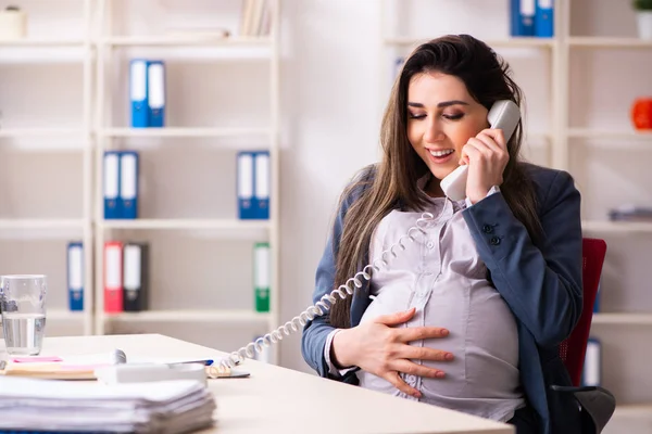 Mujer embarazada joven que trabaja en la oficina — Foto de Stock